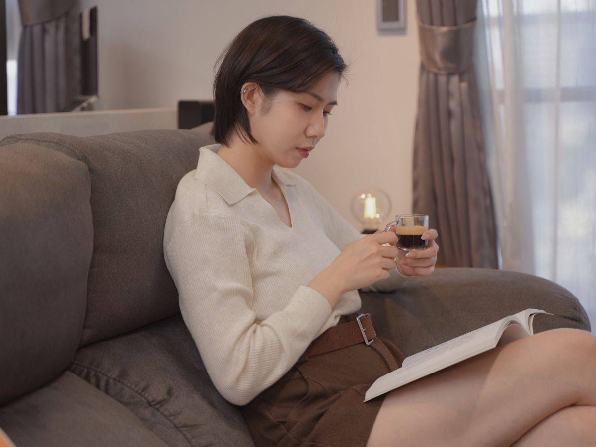 咖啡機怎麼選?為什麼我選擇 Nespresso Inissia 簡單,才是最極致的享受 - 第3張圖 在沙發上享受 Nespresso 義式濃縮咖啡,結合閱讀與咖啡香的居家放鬆時光